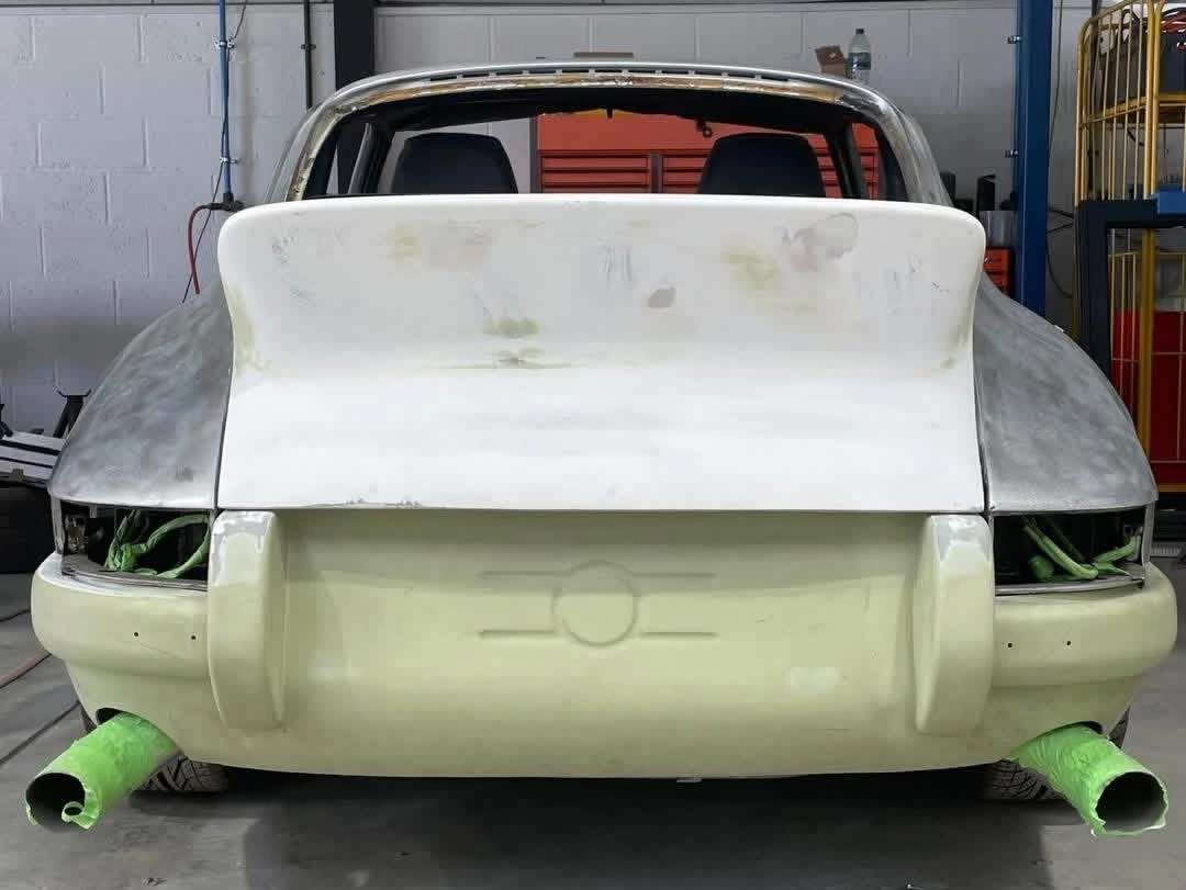 Porsche 911 rear view with spoiler and bodykit panels being fitted