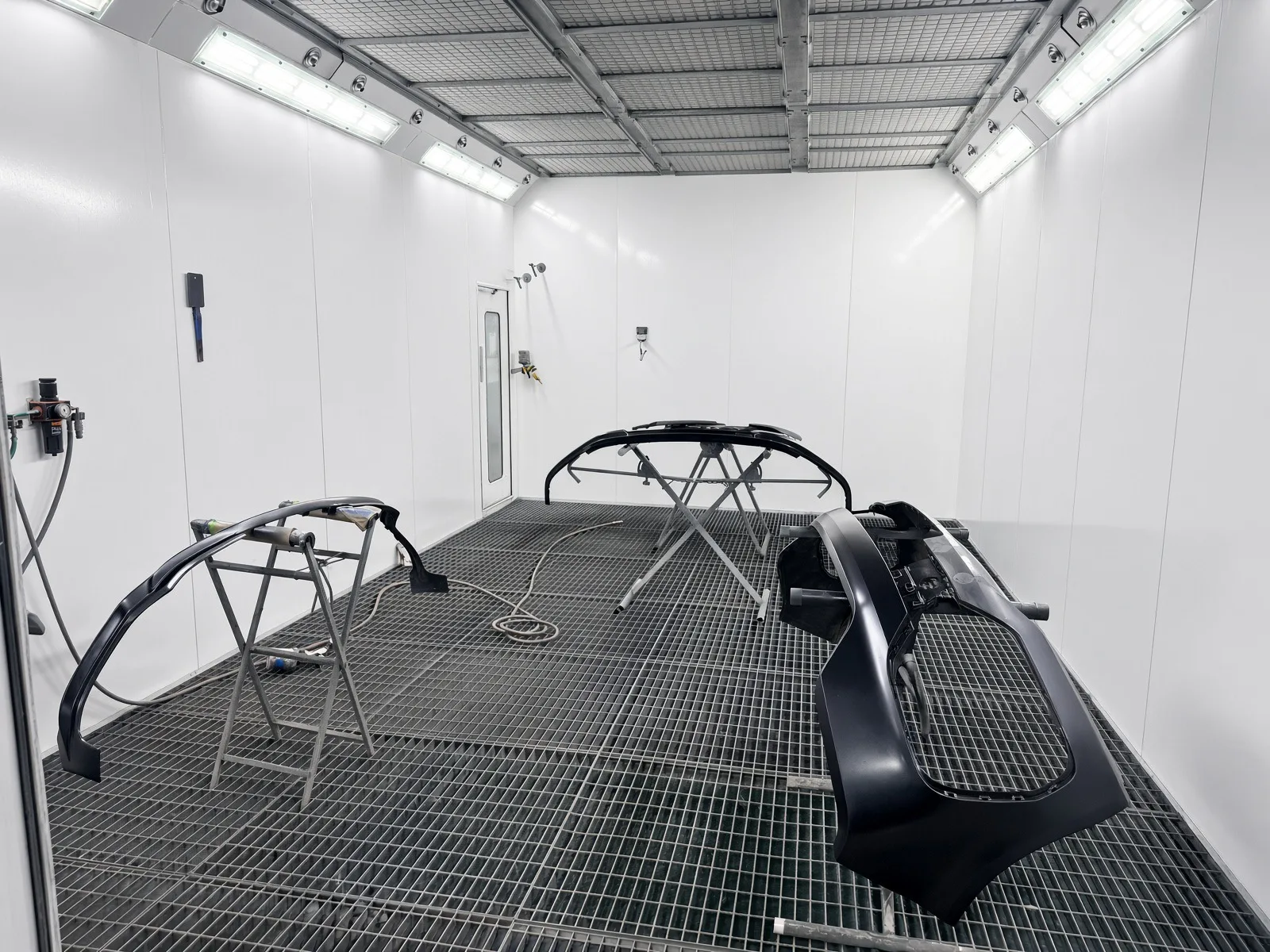 JB Bodyworks spray booth with bumpers prepared for refinishing