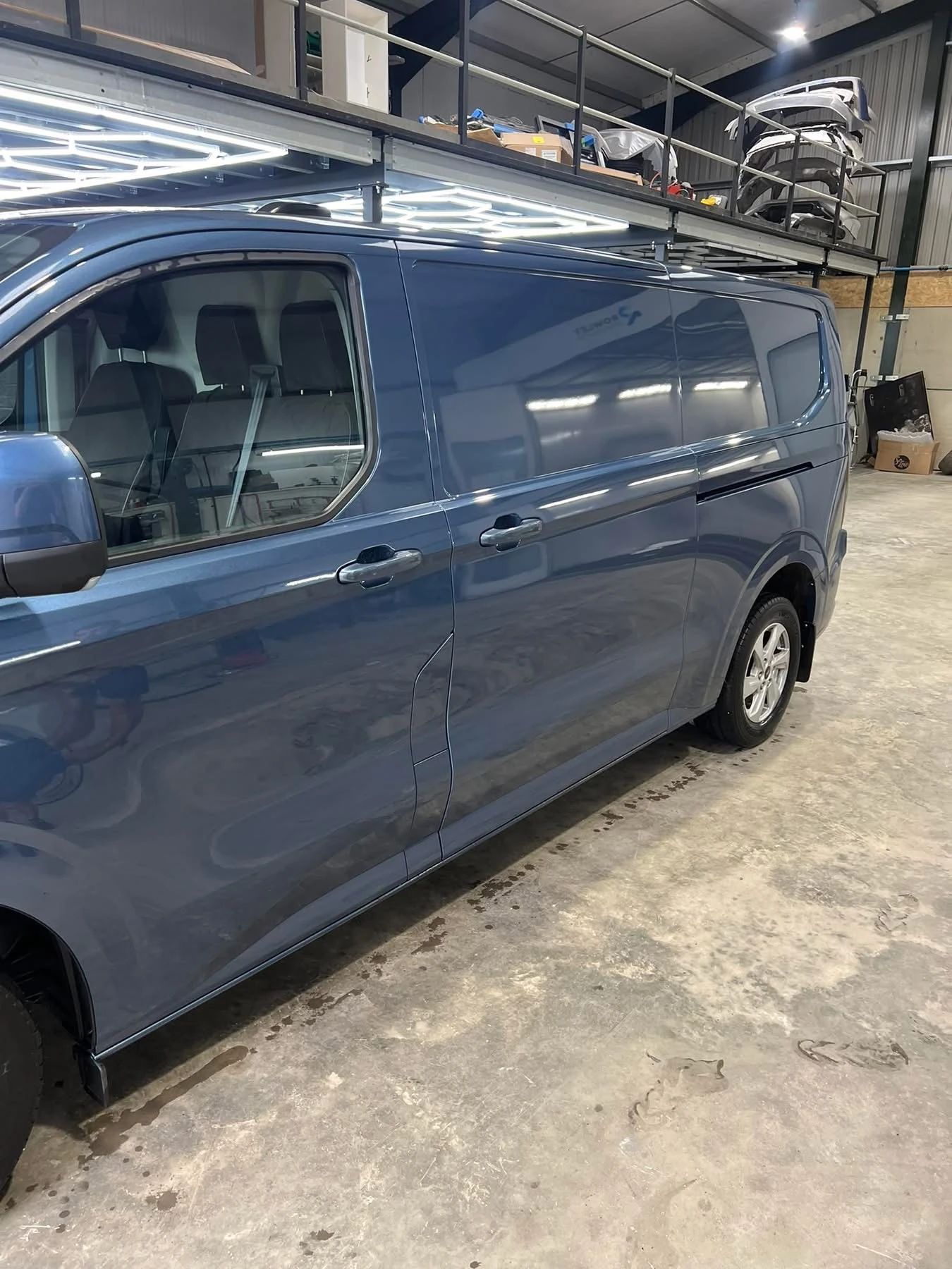 Ford Transit Custom completed loading door and rear quarter repairs, side view in the workshop