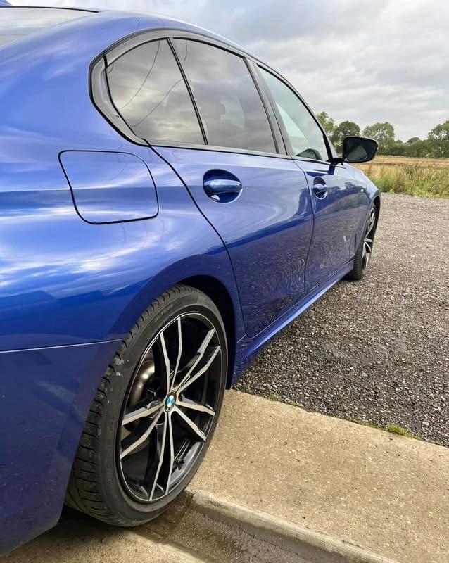 BMW 330i repaired driver's side with replacement doors reassembled, rear three-quarter view