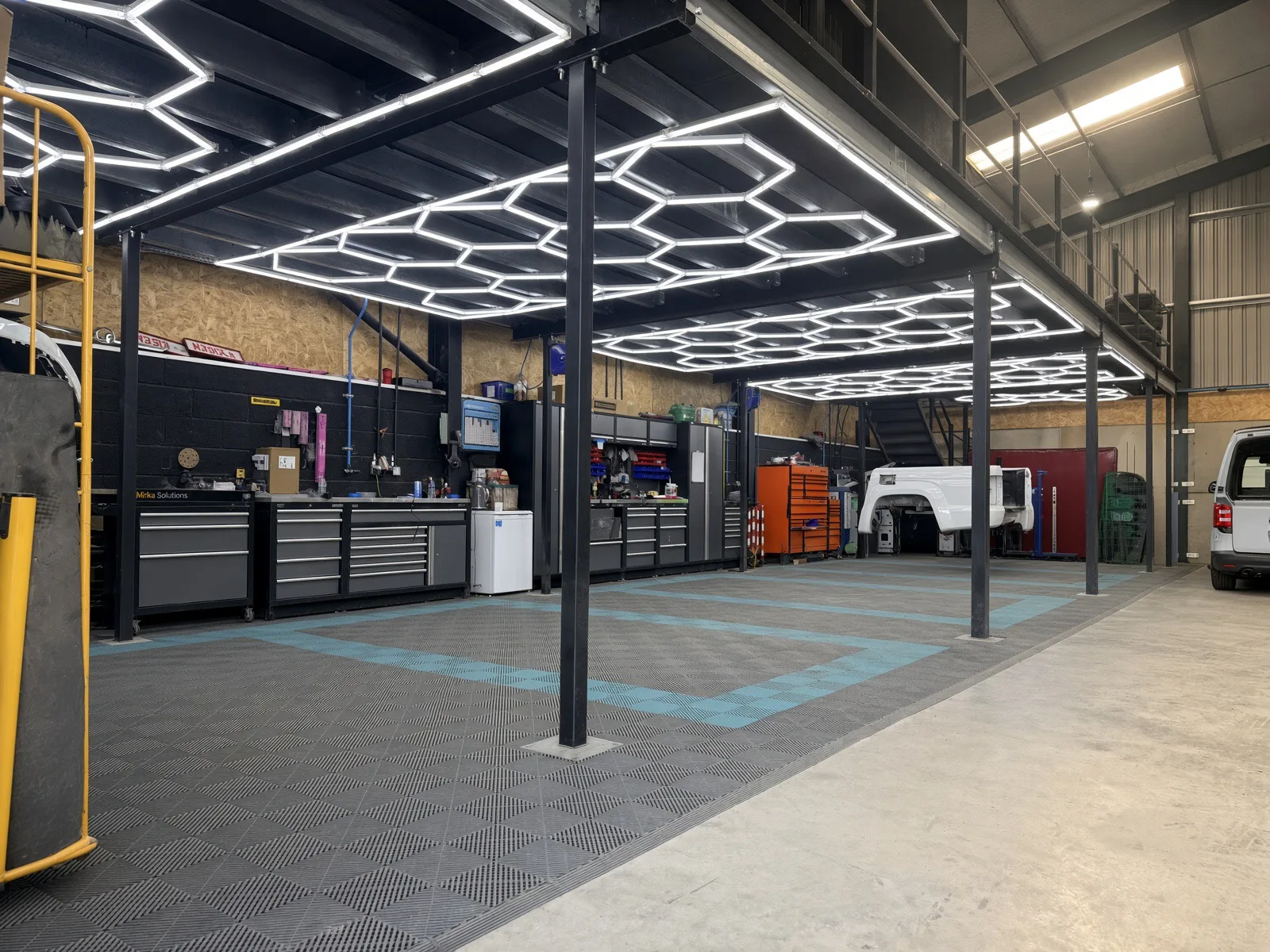 Wide view of the JB Bodyworks repair workshop with mezzanine and LED lighting