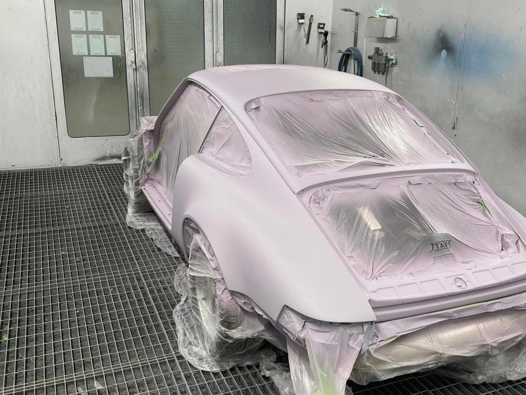 Porsche 911 masked in the spray booth with preparation coat, rear three-quarter view