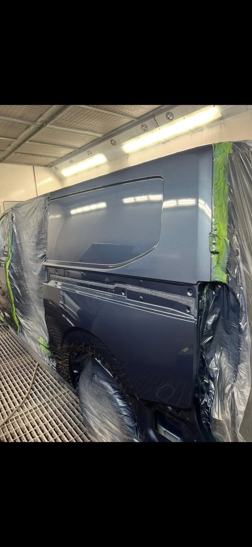 Ford Transit Custom freshly painted passenger-side rear quarter in the spray booth