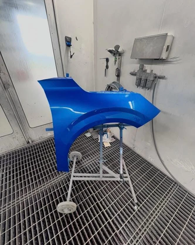 Peugeot 208 replacement front wing painted blue in the spray booth