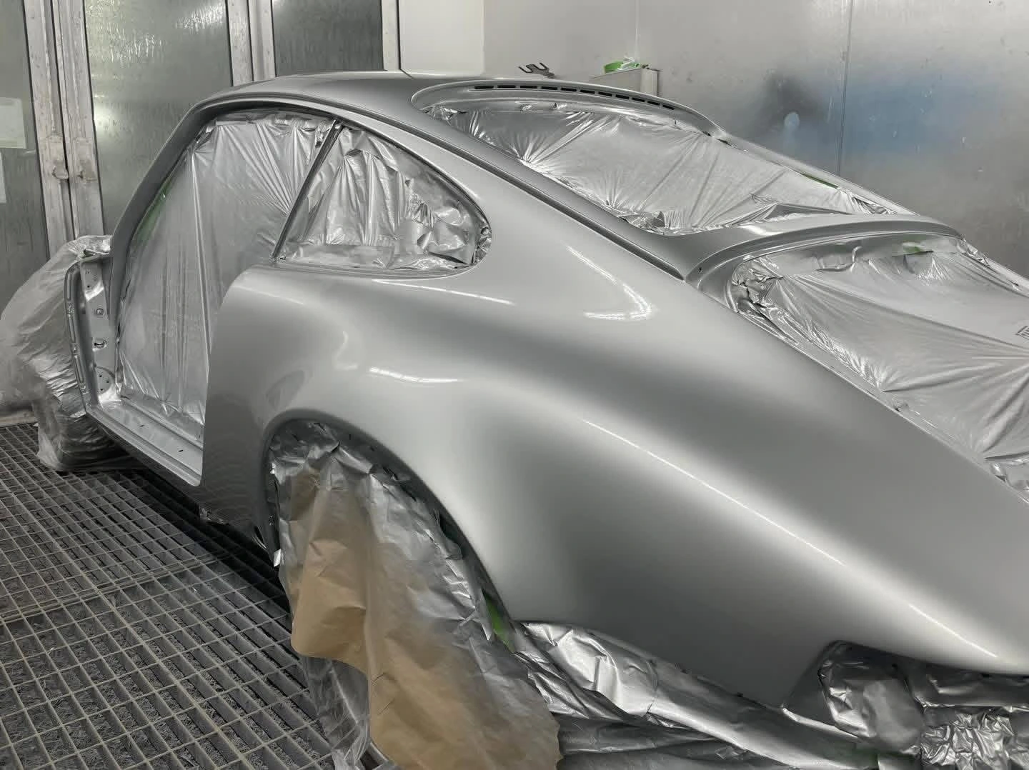Porsche 911 Diamond Silver paintwork, side and rear view while masked in the booth