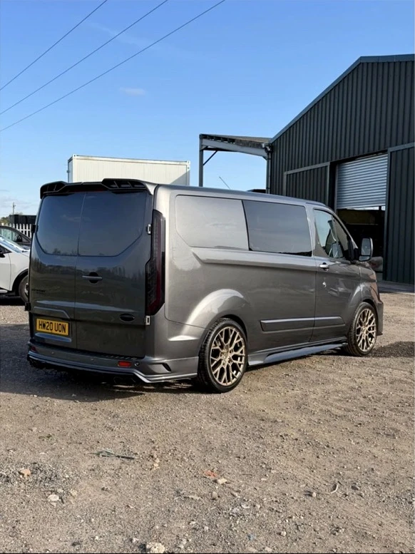 Rear of the grey custom-styled van with rear spoiler and bronze alloy wheels