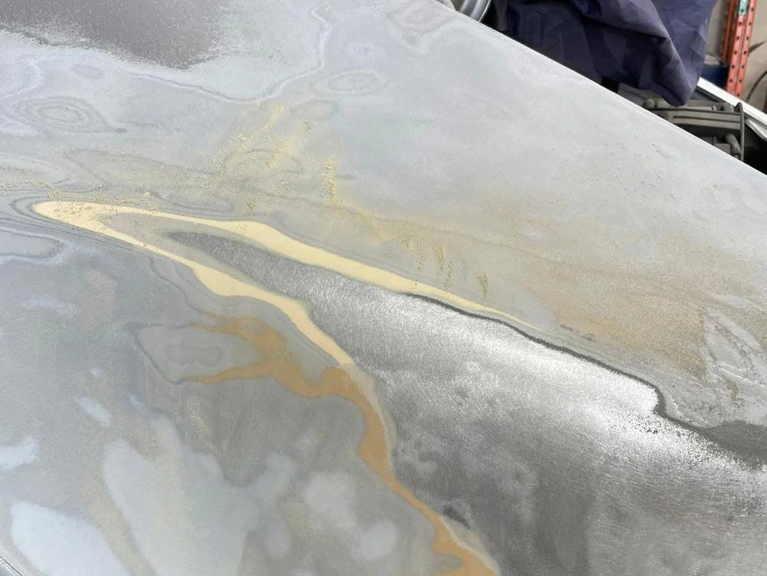 Porsche 911 bodywork close-up showing exposed metal and previous repair material