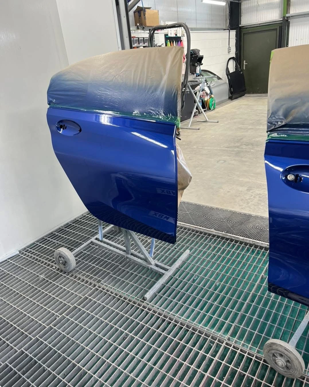 BMW 330i replacement rear door painted blue alongside the front door